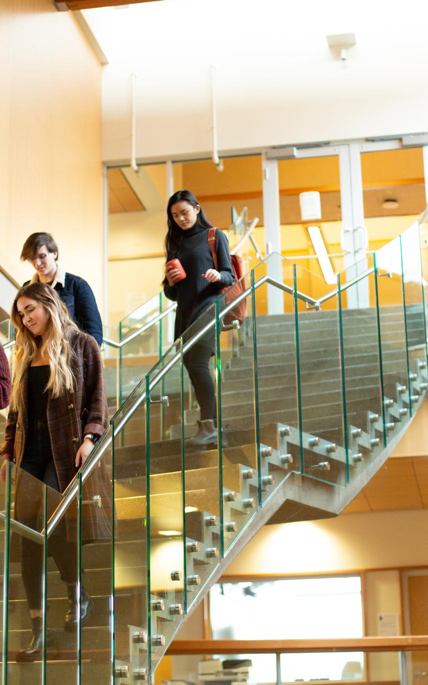 four students walk down the stairs of the Cowichan campus